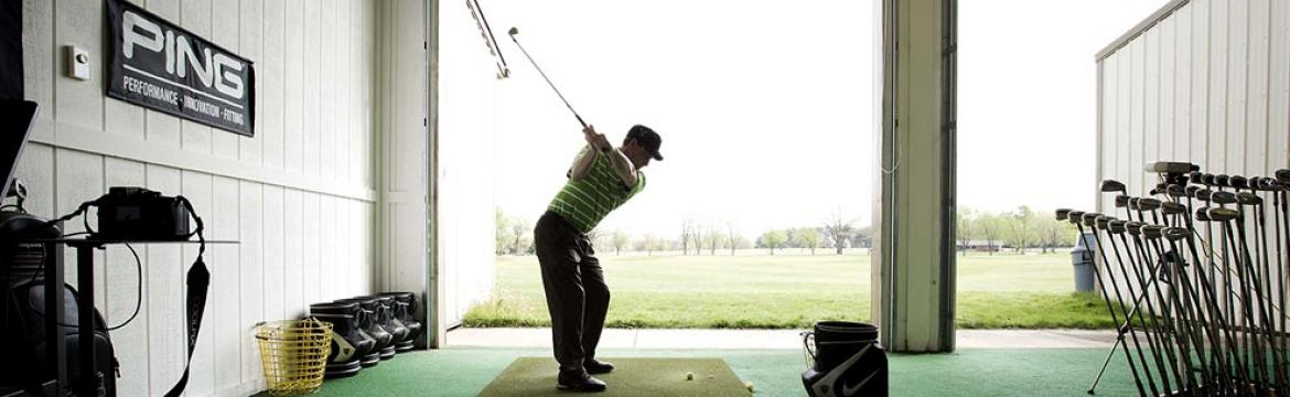 a golfer uses the practice facility at Swan Lake